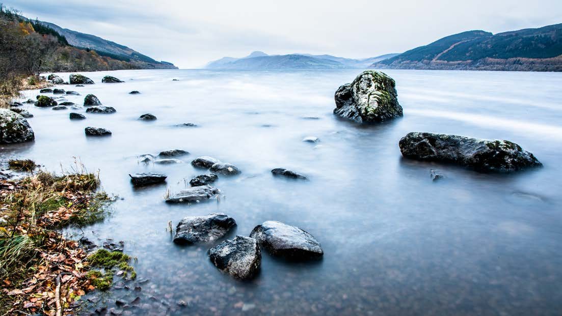 Still water and rocks on the shore of Loch Ness
